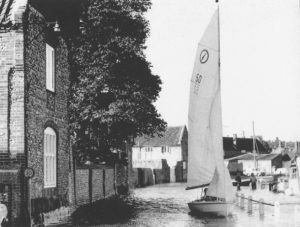 Blakeney Quay with boat sailing on road